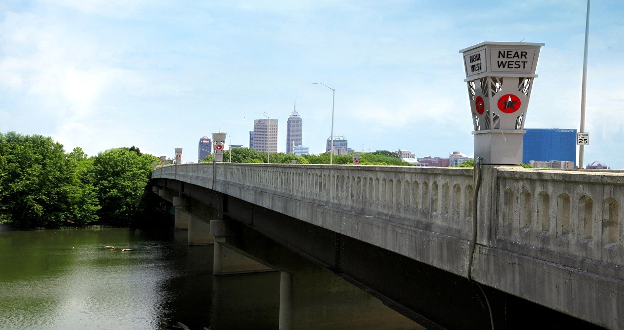 a bridge over a river with a city in the background